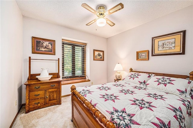 carpeted bedroom featuring ceiling fan and a textured ceiling