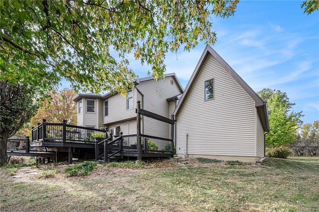 rear view of property with a deck and a lawn