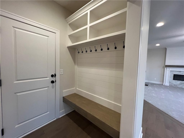 mudroom featuring dark carpet and a fireplace