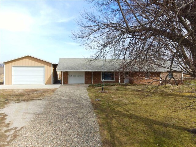 100 S Cherry St, Clearmont, MO 64431 - single story home featuring a front lawn, brick siding, and a detached garage