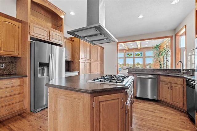 kitchen featuring decorative backsplash, appliances with stainless steel finishes, island range hood, light hardwood / wood-style floors, and a kitchen island