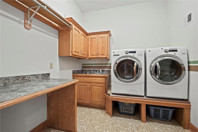 washroom with cabinets, separate washer and dryer, and sink