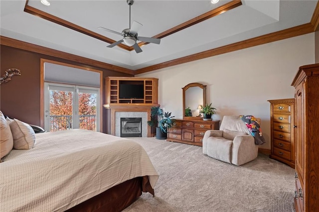 bedroom with carpet, a tray ceiling, ceiling fan, and ornamental molding