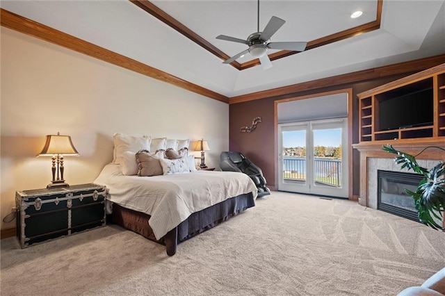 bedroom with ceiling fan, access to exterior, ornamental molding, and a tray ceiling