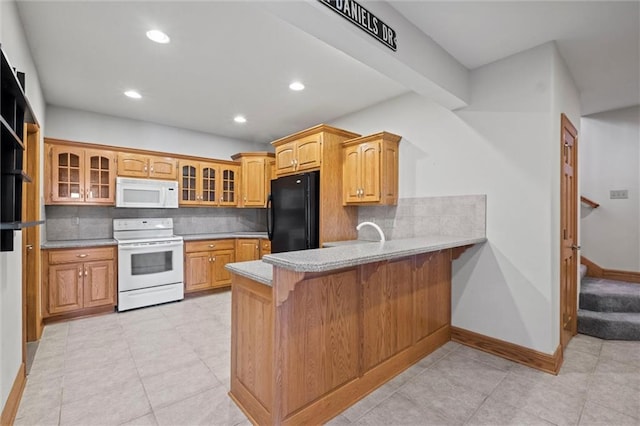 kitchen featuring a kitchen bar, kitchen peninsula, decorative backsplash, and white appliances