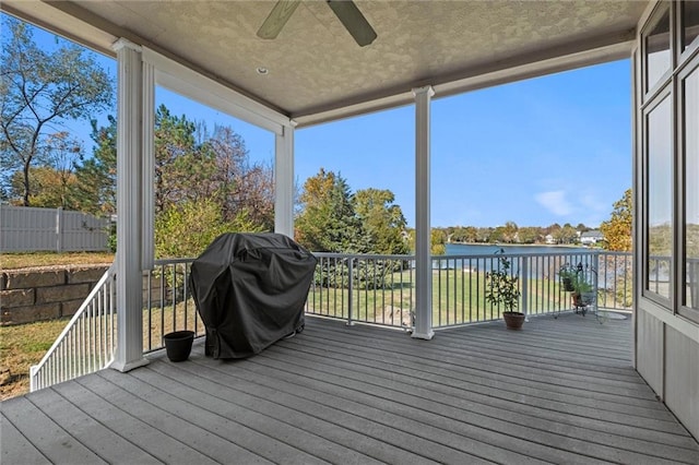 sunroom / solarium with a water view, plenty of natural light, and ceiling fan