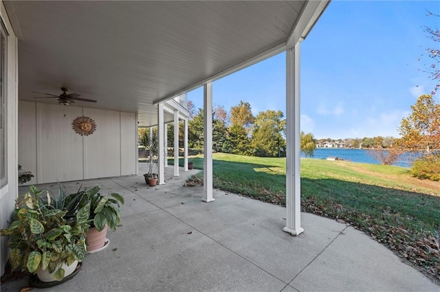 view of patio with a water view and ceiling fan