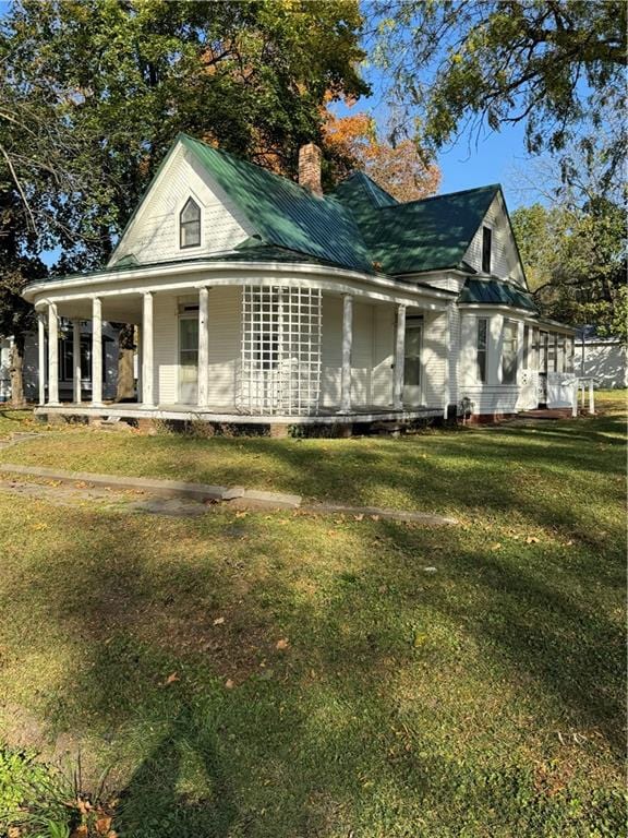 view of side of home with a porch and a lawn