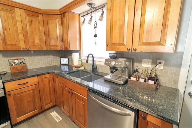 kitchen featuring dark stone counters, dishwasher, sink, and decorative backsplash