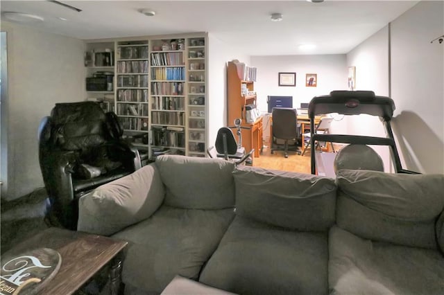 living room featuring wood-type flooring and built in features