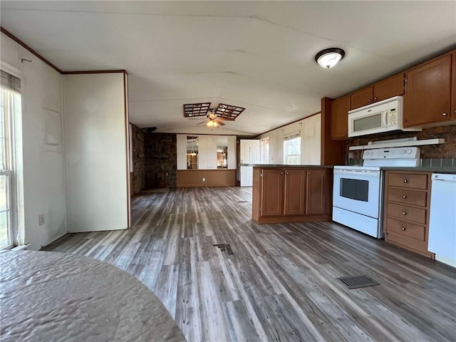 kitchen featuring white appliances, ceiling fan, lofted ceiling, decorative backsplash, and dark hardwood / wood-style floors