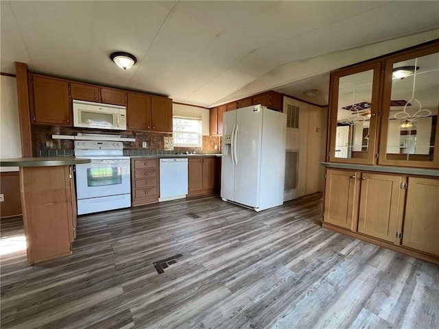 kitchen with lofted ceiling, dark hardwood / wood-style flooring, backsplash, sink, and white appliances