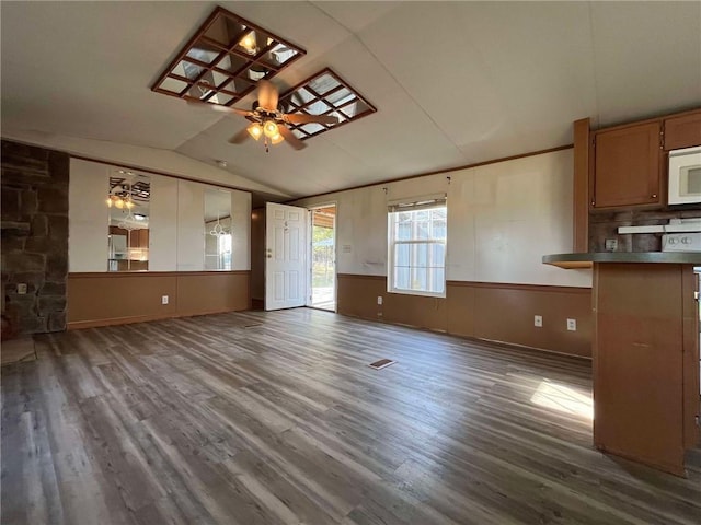 unfurnished living room featuring dark hardwood / wood-style flooring, lofted ceiling, and ceiling fan