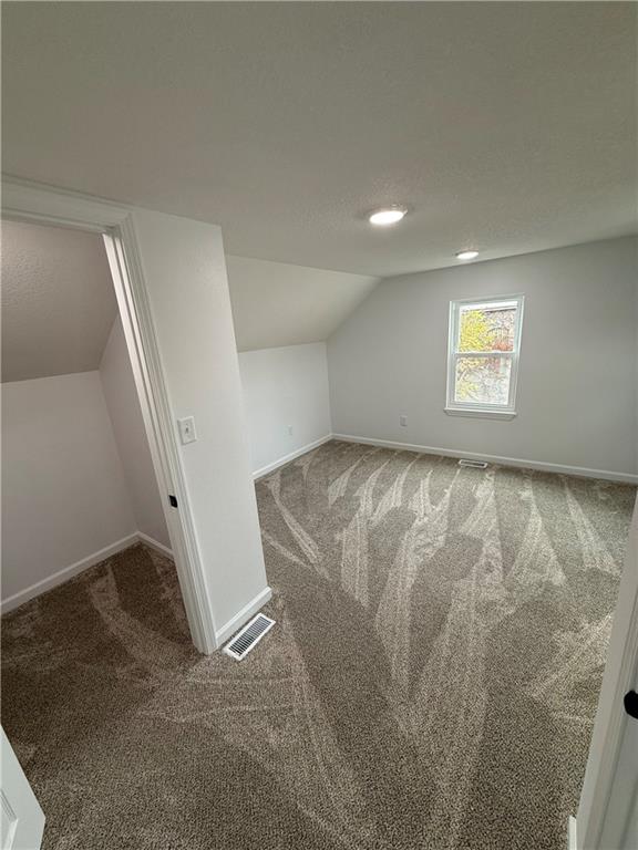 bonus room with carpet and vaulted ceiling