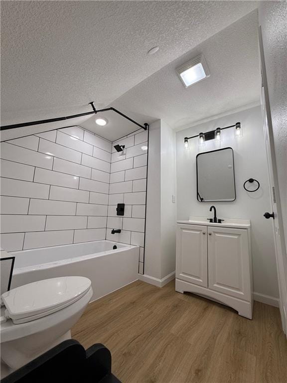 full bathroom featuring vanity, toilet, hardwood / wood-style flooring, and tiled shower / bath