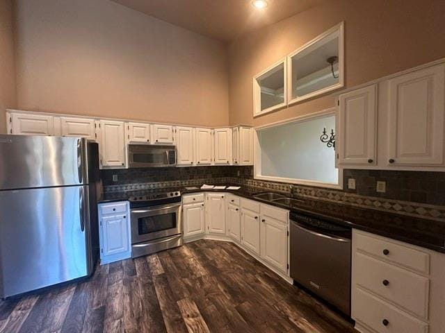 kitchen with appliances with stainless steel finishes, white cabinets, and dark hardwood / wood-style flooring