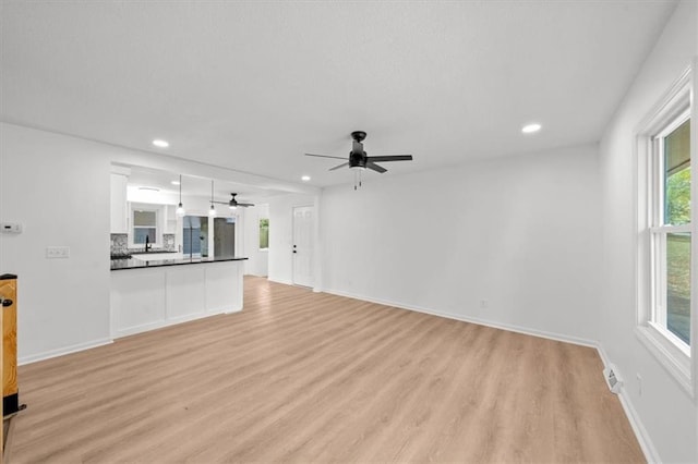 unfurnished living room featuring light wood-type flooring and ceiling fan