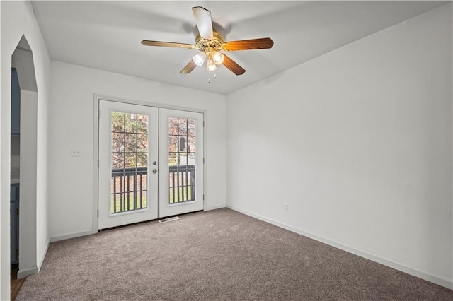 carpeted empty room featuring french doors and ceiling fan