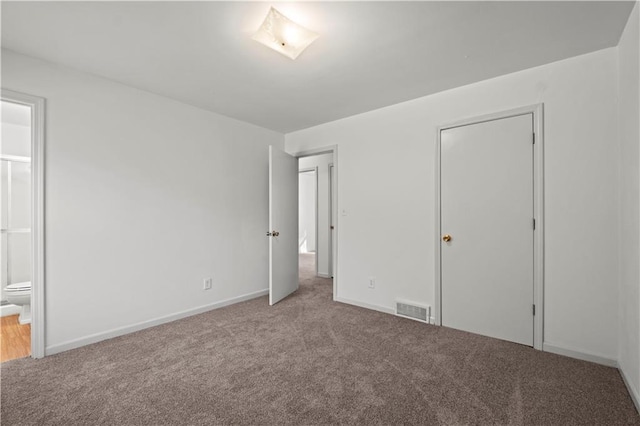 unfurnished bedroom with connected bathroom, light colored carpet, and a closet