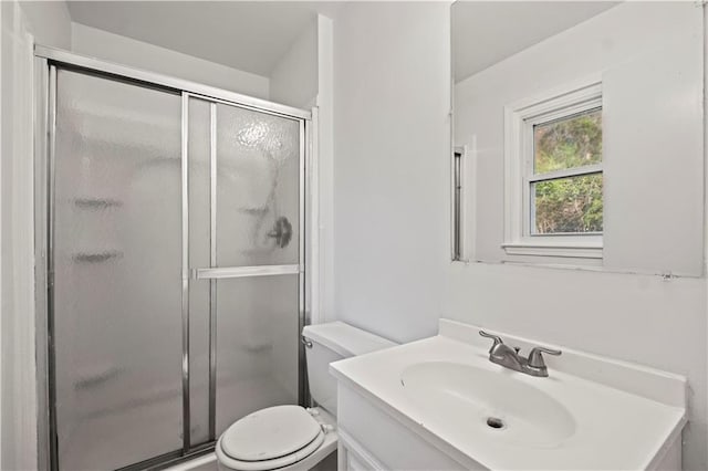 bathroom with a shower with door, vanity, and toilet