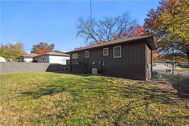 rear view of property with a yard and central AC