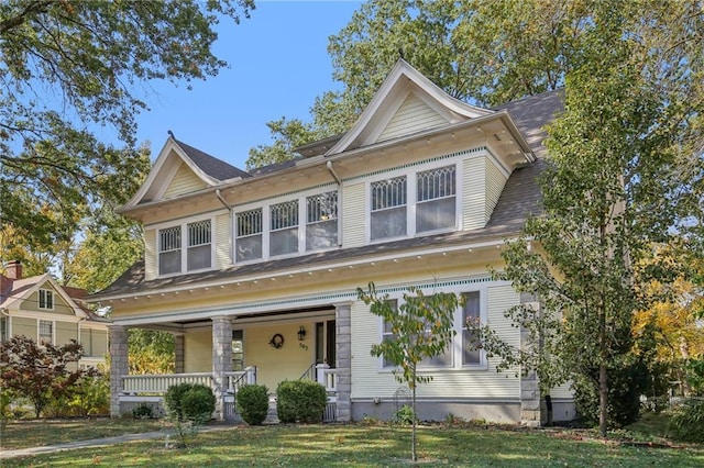 view of front of house featuring covered porch and a front lawn