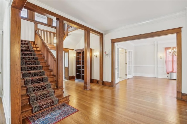 503 S 2nd St, Clinton, MO 64735 - staircase with radiator, wood finished floors, a chandelier, baseboards, and crown molding