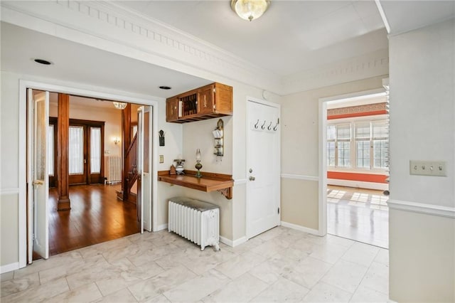 kitchen featuring radiator heating unit, light hardwood / wood-style floors, and ornamental molding