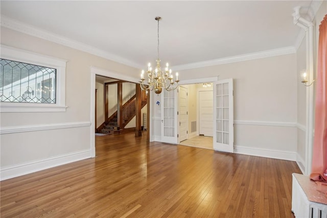 503 S 2nd St, Clinton, MO 64735 - unfurnished dining area with stairs, light wood-style flooring, a chandelier, baseboards, and french doors