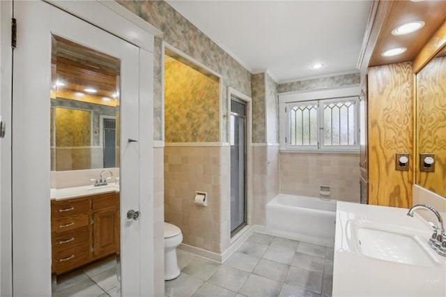 full bathroom with plus walk in shower, tile patterned floors, toilet, vanity, and tile walls