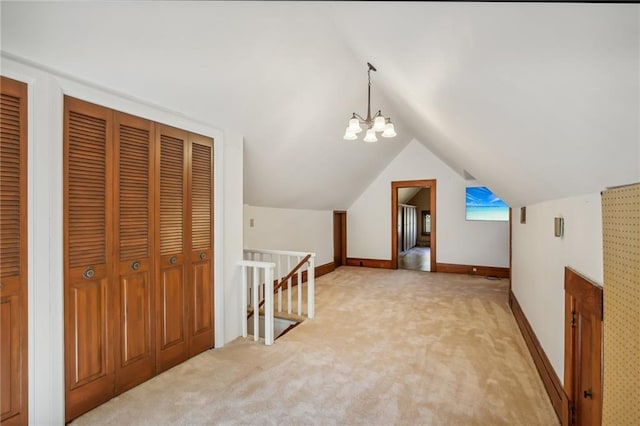 additional living space featuring a chandelier, light colored carpet, and vaulted ceiling