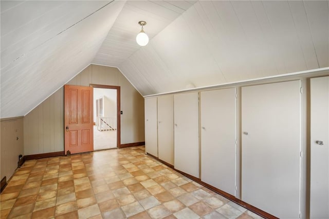 503 S 2nd St, Clinton, MO 64735 - bonus room featuring baseboards, lofted ceiling, wood walls, and stone finish flooring