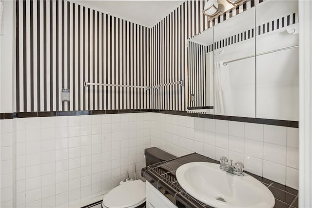 503 S 2nd St, Clinton, MO 64735 - bathroom featuring wallpapered walls, toilet, tile walls, vanity, and decorative backsplash