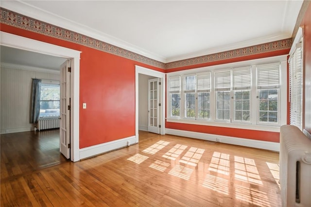 503 S 2nd St, Clinton, MO 64735 - spare room with radiator heating unit, hardwood / wood-style floors, baseboards, and crown molding