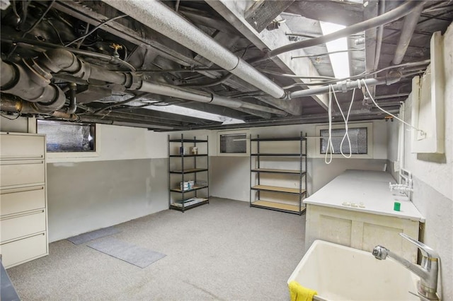 basement featuring light carpet and sink