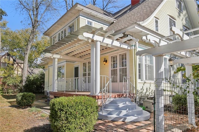 503 S 2nd St, Clinton, MO 64735 - entrance to property with a pergola, a porch, a chimney, and roof with shingles