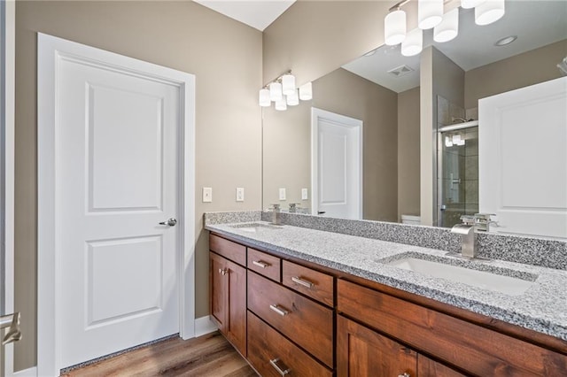 bathroom featuring vanity, hardwood / wood-style floors, and a shower with shower door