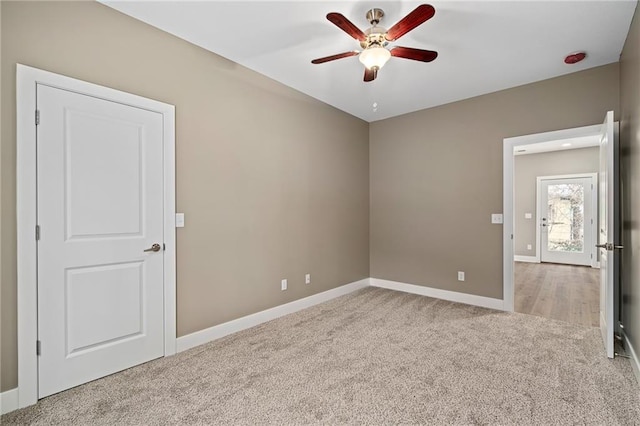 spare room featuring light carpet and ceiling fan