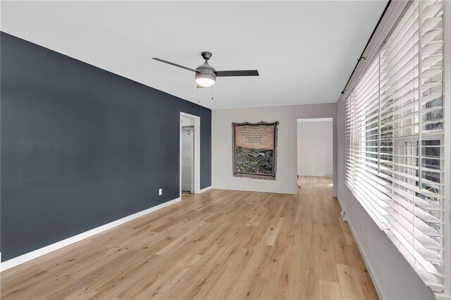 spare room with light wood-type flooring and ceiling fan