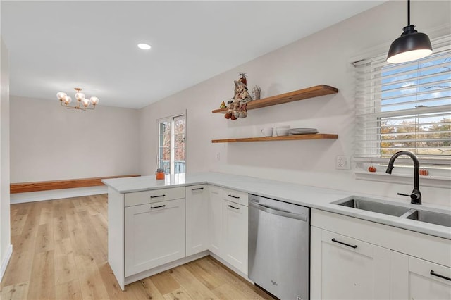 kitchen featuring white cabinets, stainless steel dishwasher, sink, and a wealth of natural light