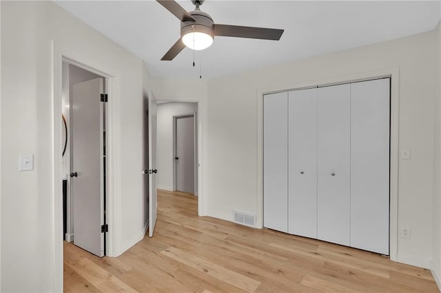 unfurnished bedroom featuring a closet, light hardwood / wood-style floors, and ceiling fan