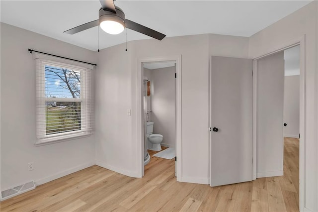 unfurnished bedroom with connected bathroom, light wood-type flooring, and ceiling fan