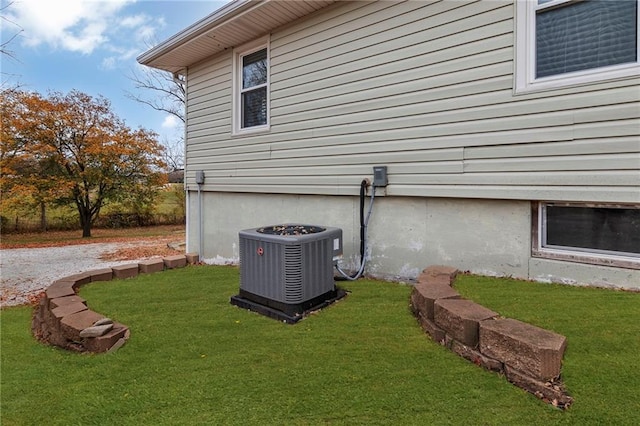 view of side of property with a yard and cooling unit