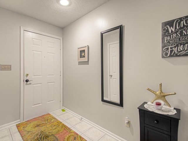 entrance foyer with a textured ceiling and light tile patterned flooring