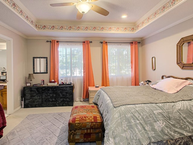 bedroom with ceiling fan, crown molding, light carpet, and a raised ceiling