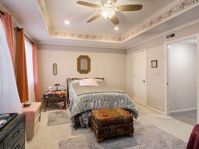 carpeted bedroom featuring crown molding, a textured ceiling, a tray ceiling, and ceiling fan