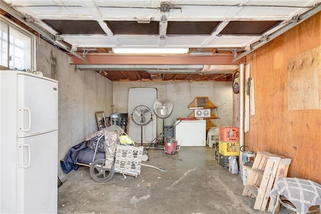 basement featuring washer / dryer and white refrigerator