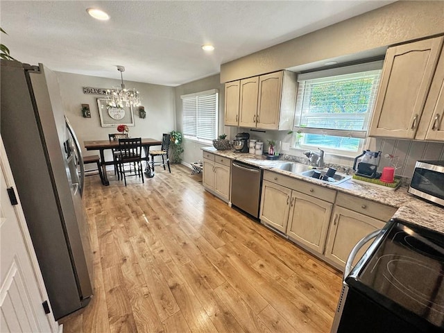 kitchen featuring light brown cabinets, light wood-type flooring, stainless steel appliances, and sink