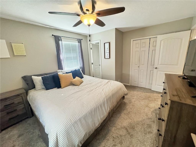 bedroom featuring ceiling fan, light carpet, and a closet