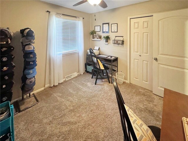 carpeted office space featuring ceiling fan